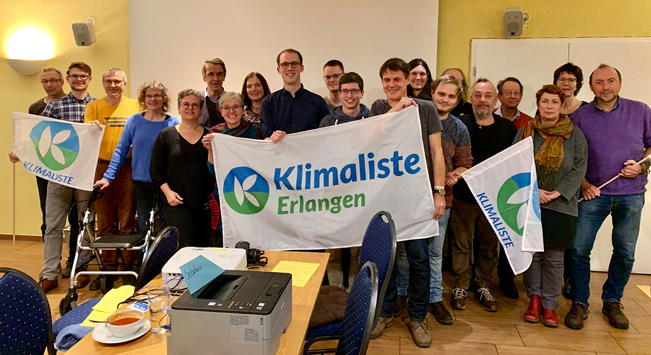 Gruppenbild der Erlanger Klimaliste mit dem Banner und den Logos der Klimaliste